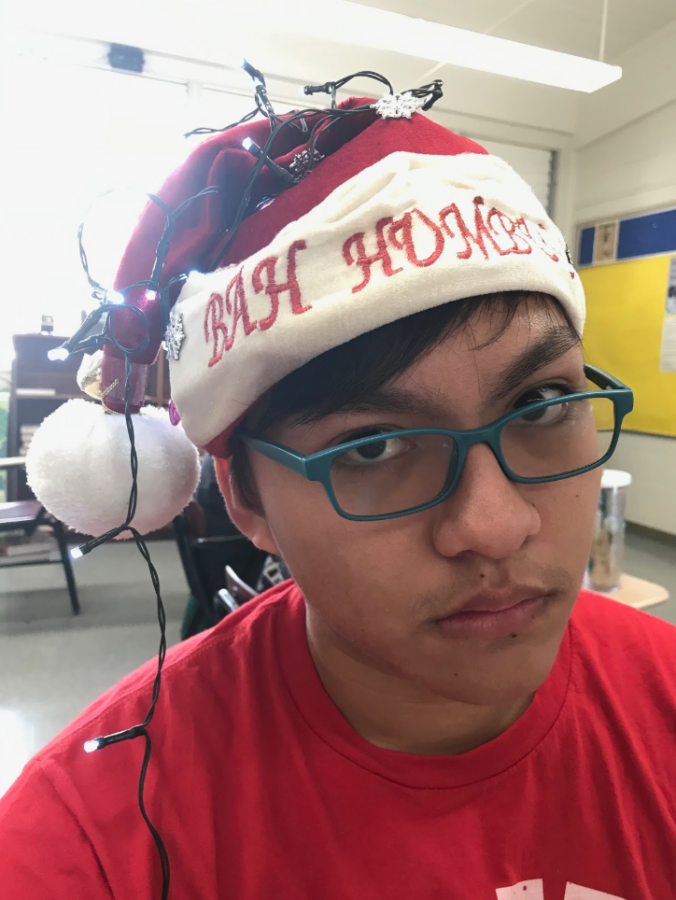 “I love Spirit Week because it’s more fun to see other people dress as lunatics,” Jonah Sablan (11) said. Sablan has dressed up every day and tops off todays outfit with an ironic “Bah Humbug” hat. Photo by Kacie Huang 2019. 