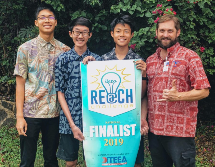 From left to right: Andy Au (10), Codie Nakamura (10),  Zi Tao Li (10), and their Robotics teacher Bryan Silver pose with their REACH Challenge Finalist banner. Photo courtesy of Zi Tao Li 2020. 