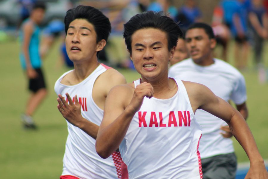 Jay Suh (10) and Aiden Cheung (10) battle down the straight in the 100m dash at the first OIA Track & Field meet of the season at Moanalua High School on March 7. Photo by Monica Mau. 