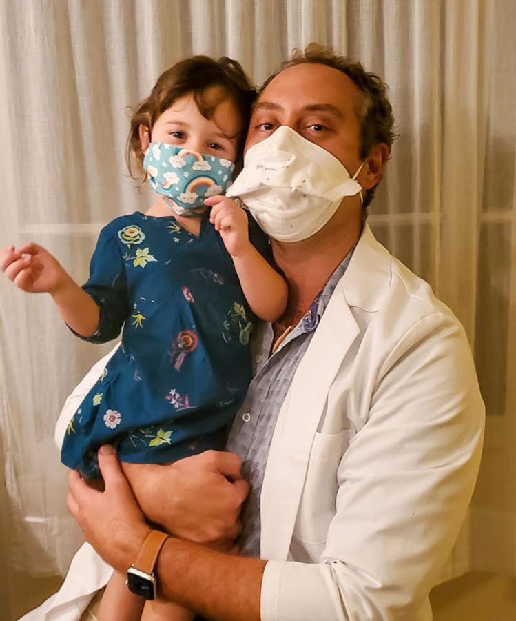 Dr. Richard Kline and his 2-year-old daughter, Julia, are pictured both wearing masks. Despite his wifes doubts early on in the COVID-19 pandemic, Julia is actually incredibly good at wearing a mask. Ive taught her that if she sees people, she needs to wear a mask, Dr. Kline said. Since last March, he has worked non-stop and credits his family as helping him get through these challenging times. Photo and caption by Lily Washburn. 