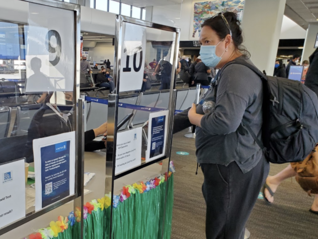 Emilani Crow shows an attendant her negative COVID-19 test result before boarding her returning flight to Hawaii from San Francisco on April 6, 2021. Travelers returning to Hawaii must have a negative test result taken within 72 hours or they are required to complete a 10-day self-quarantine upon their arrival. Photo and caption by Lily Washburn. 