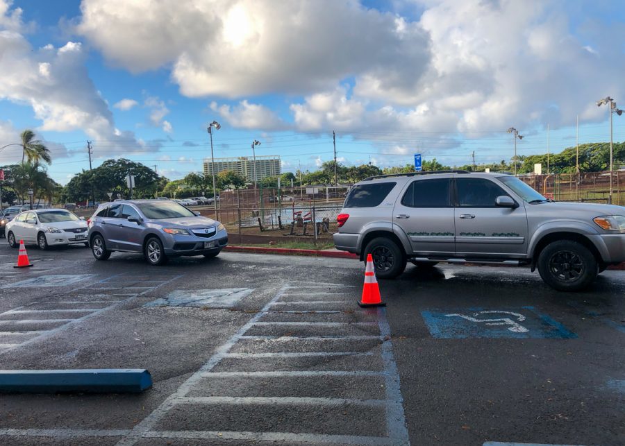 A long line of cars circle the track on Sept. 13 as parents wait to drop off their students at Kalani. Photo by Leilani Phan. 