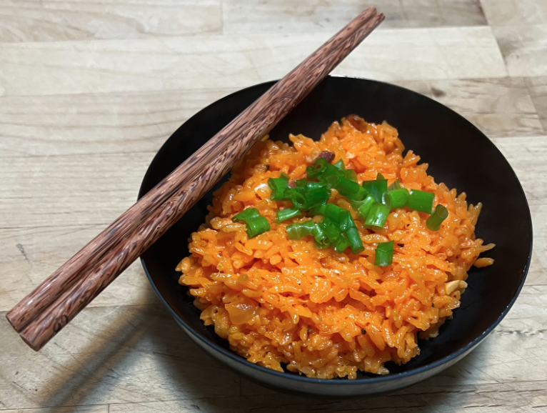 The dish can be either a main or a side. Short-grained rice prepared with water colored from soaking achiote (annatto) seeds gives it a deep orange color.