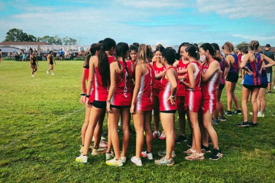 The varsity girls team huddles up for the team scream before the third race of our season on Sept. 17, 2022 at Pearl City High School.