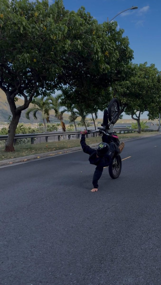 Christian Kekai does a floor touch trick on his e-bike on Aug. 20. The proliferation of e-bikes in busy areas presents growing safety hazards for students. 