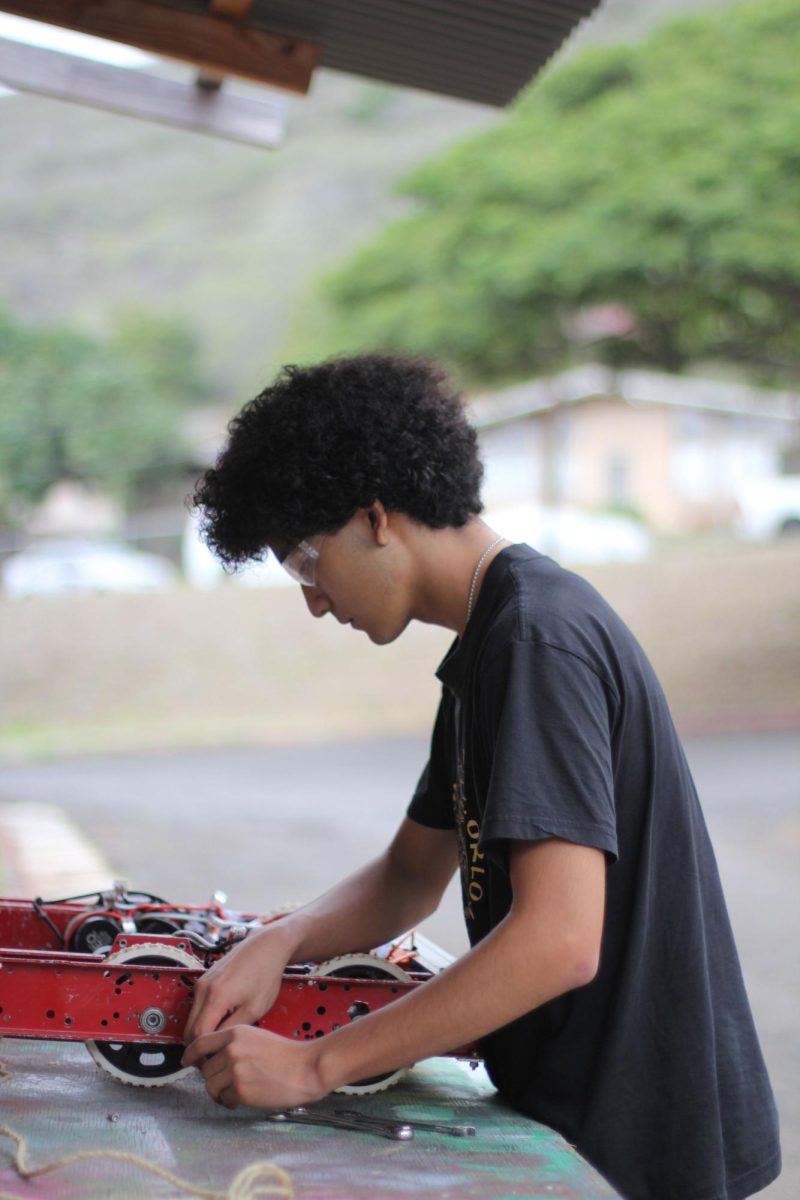 Rodrigo Del Carpio (11) works on the mechanical components of a robot, applying the same focus he has used during his three years with the Kalani High School robotics program. As the FRC team captain, Del Carpio manages a schedule that often requires him to stay at school until 7 p.m. to prepare for state competitions. 