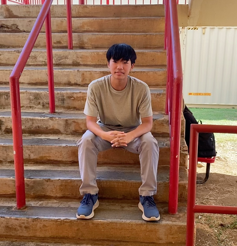Kalani freshman Stevens Au sits on a staircase on campus, reflecting on a busy schedule that begins with a 5 a.m. wake-up call in Ewa Beach. Au believes personal motivation and building friendships are more important than straight As. 