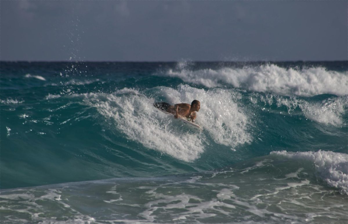 A bodyboarder maneuvers across a breaking wave. Ben Low, who frequently surfs at Makaha Beach, views bodyboarding as his way to stay connected to Hawaii and find a sense of accomplishment through riding large waves.