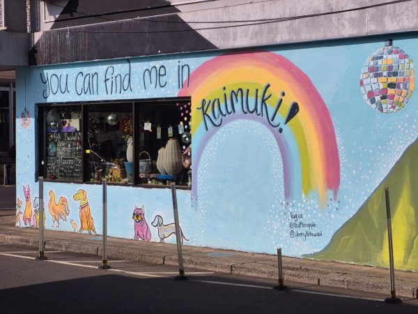 The Red Pineapple gift shop is shown with a mural, welcoming shoppers both local and tourist to the neighborhood.